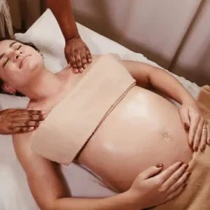 Terapis profesional melakukan pijat relaksasi lembut pada area punggung dan bahu ibu hamil di Zavra Massage